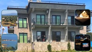 Um edifício moderno de dois andares com fachada de pedra, janelas amplas e uma varanda.