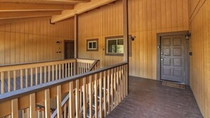Une façade en bois avec un balcon, une porte et une fenêtre.