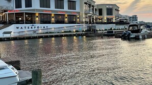 Een restaurant aan het water met verschillende eetgelegenheden, waaronder een sushi bar, zeevruchten en ramen.