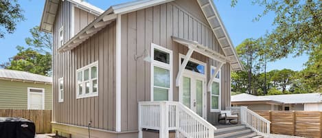 A two-story house with a front porch, a covered patio, and a small deck.