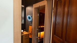 A narrow hallway leading to a bedroom with a wooden door, a bedside table, and a bed with a headboard. - Cozy apartment with high comfort for max. 6 people TIP bookable from 27.12.2025  (Schmitten)