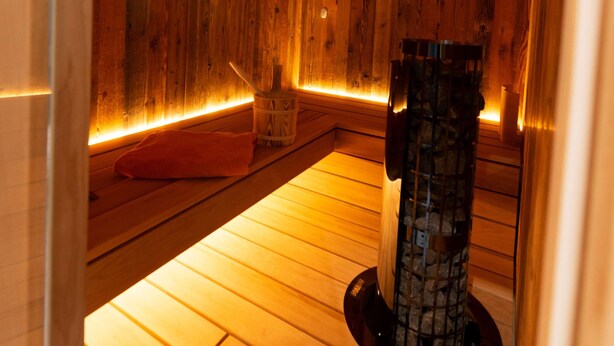 A sauna room with wooden walls and a central stone pillar. - Cozy apartment with high comfort for max. 6 people TIP bookable from 27.12.2025  (Schmitten)