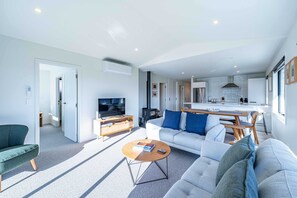 A modern living room with a sofa, coffee table, and TV.