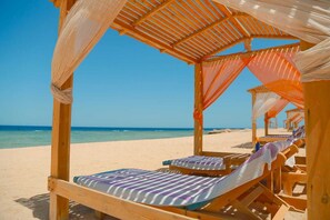 A beach cabana with wooden benches and a canopy. - Beach Safari Nubian Resort - All inclusive (Marsa Alam)