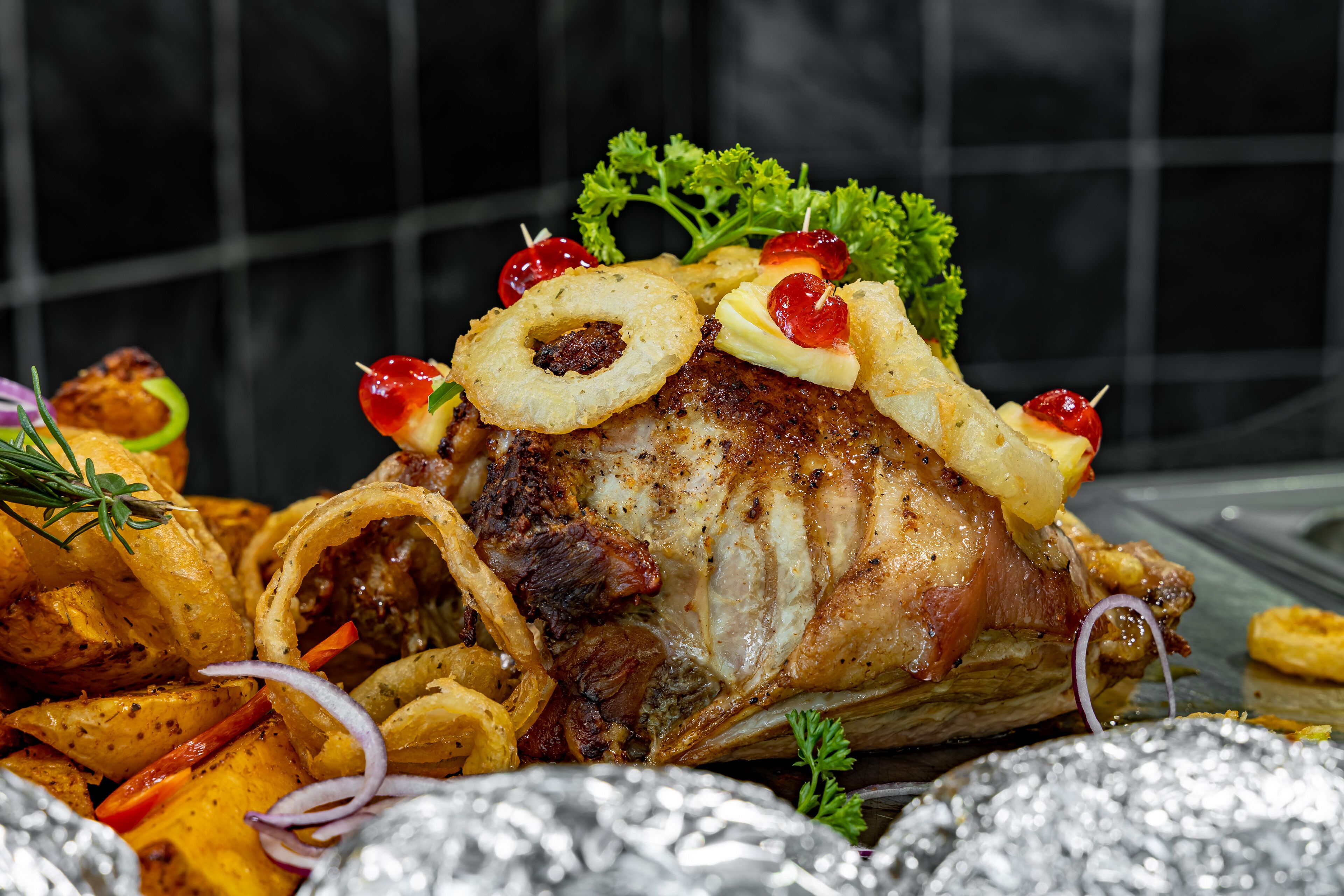A roasted pork dish with garnishes and sides.