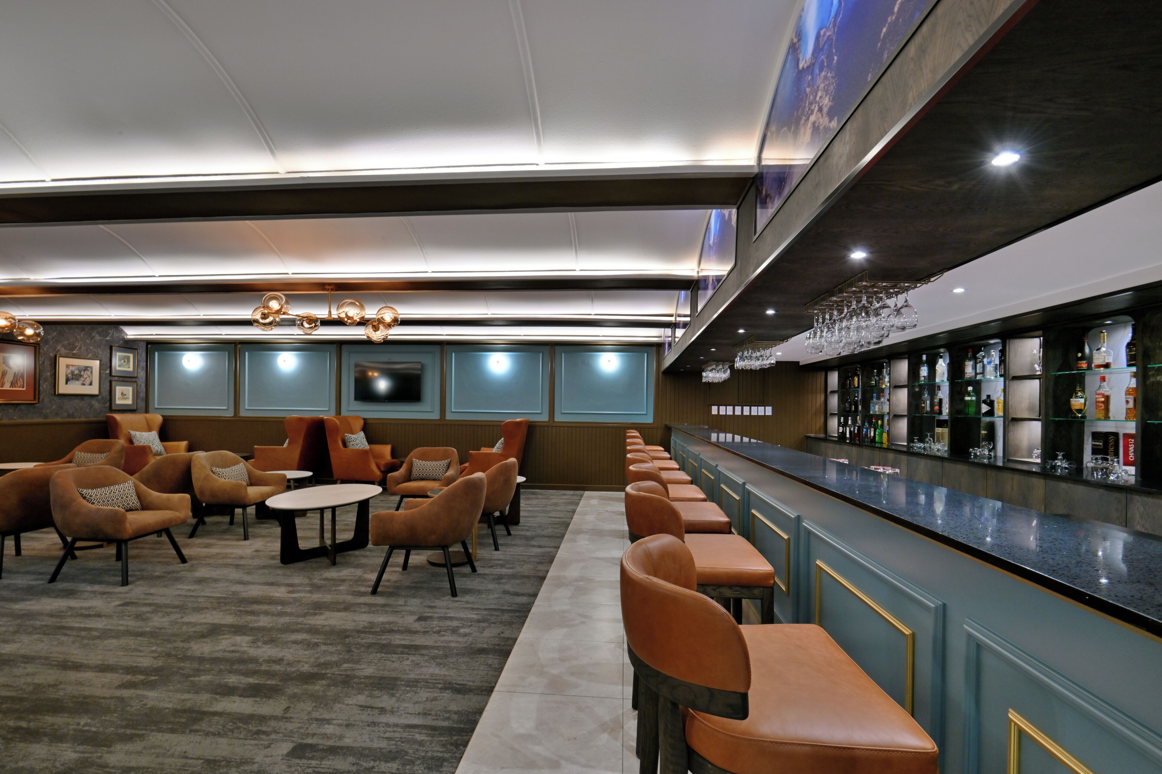 A bar area with seating, a counter, and a television screen.