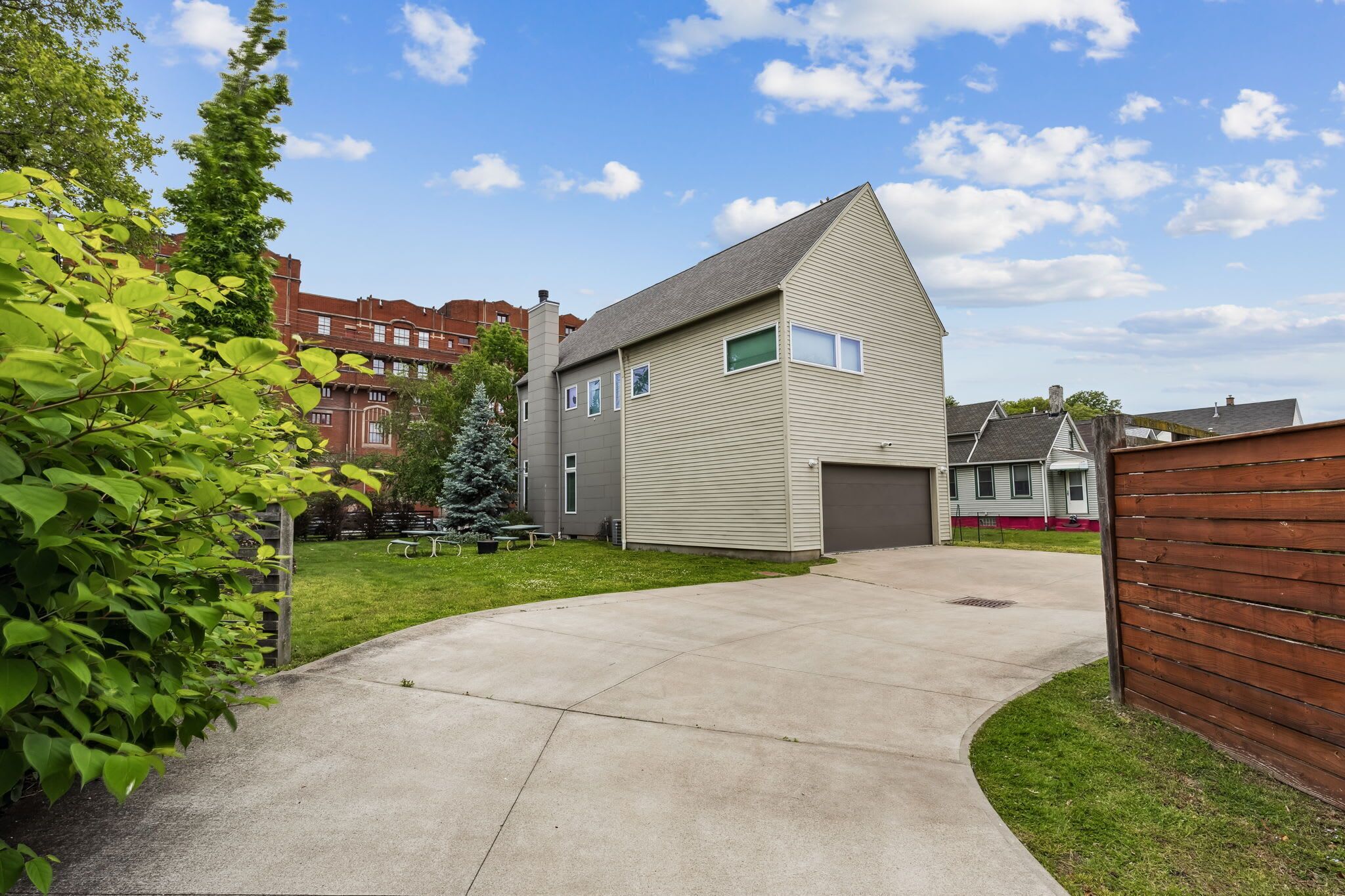 A residential building with a garage, a driveway, and a well-maintained lawn.