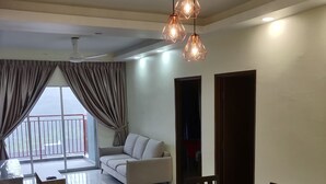 Un vaste espace de vie comprenant une table à manger, des chaises, un canapé et un balcon doté d’une rambarde.