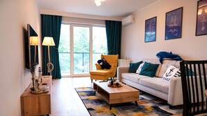 Una sala de estar moderna con un sofá, un sillón, una mesa de centro y vistas a través de un ventanal.