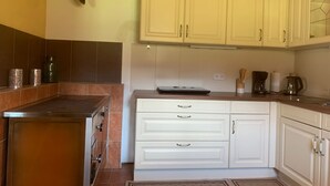 Een keuken met witte kastjes, een roestvrijstalen afzuigkap en een betegelde achterwand.