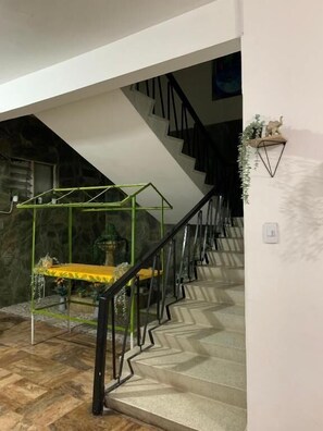 A staircase with a geometric patterned floor, a green metal structure, and a black railing. - HOSTAL RINCON DE GRANADA (Cali)