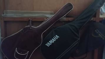 A dark-colored guitar and a black case with the Yamaha logo.