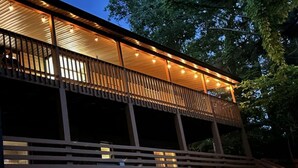 A modern building with a wooden balcony and a series of lights along the railing. - Bella's Vista - Hound Dog Haven (Bella Vista)