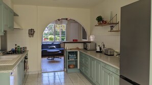 Una cocina con una zona de estar integrada, refrigerador, microondas y tostadora.