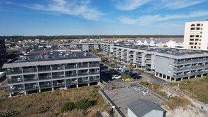 Un parking à étages, doté de plusieurs niveaux, entouré de bâtiments modernes et sous un ciel dégagé.