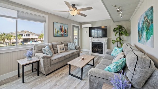 A living room with a sofa, coffee table, and a fireplace. - Betty Boo - Channel House w/Pool in Cherry Grove (North Myrtle Beach)