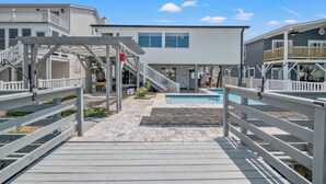 A resort with a pool, wooden deck, and multiple buildings with balconies. - Betty Boo - Channel House w/Pool in Cherry Grove (North Myrtle Beach)