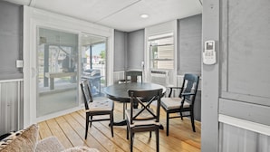 A covered patio with a round table and four chairs, a sliding glass door leading to a deck, and a view of the outside. - Betty Boo - Channel House w/Pool in Cherry Grove (North Myrtle Beach)