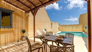 A covered outdoor dining area with a pool, wooden furniture, and a view of the sky. - Escape w/Private pool, indoor hot tub & BBQ terrace (Ix-Xaghra)