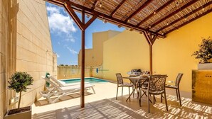 A covered outdoor area with a pool, lounge chairs, and a dining table with chairs. - Escape w/Private pool, indoor hot tub & BBQ terrace (Ix-Xaghra)