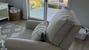 A living room with a striped sofa, a white side table, and a wicker basket.