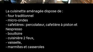 A compact kitchenette with a traditional stove, a sink, and a microwave. - La Maison de Jo (Saint Paul)