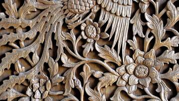 Un panel de madera tallada con detalle, con motivos florales y de hojas.