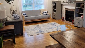 A modern living room with a sofa, a dining table, a fireplace, and a television. - A relaxing family home with a fenced in backyard (Yarmouth)
