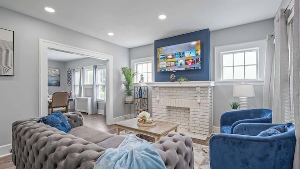 A living room with a fireplace, a television, and a sofa. - 3 bedroom 1 bath house-Free Parking-10 min to EWR. (Irvington)