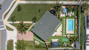 Vue aérienne d’une propriété dotée d’une piscine, d’un espace patio et d’une pelouse.