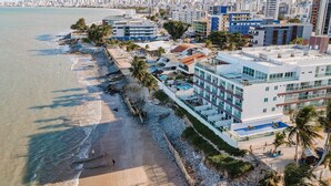 A coastal hotel with a beach view, multiple floors, and a pool area. - Flamboyant Caribessa (João Pessoa)