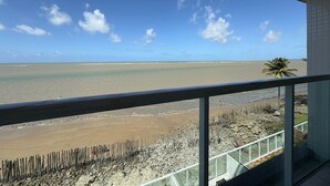 A balcony with a view of the beach and ocean. - Flamboyant Caribessa (João Pessoa)