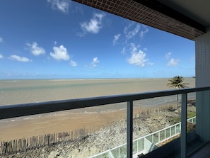 Ein Balkon mit Blick auf Strand und Meer.