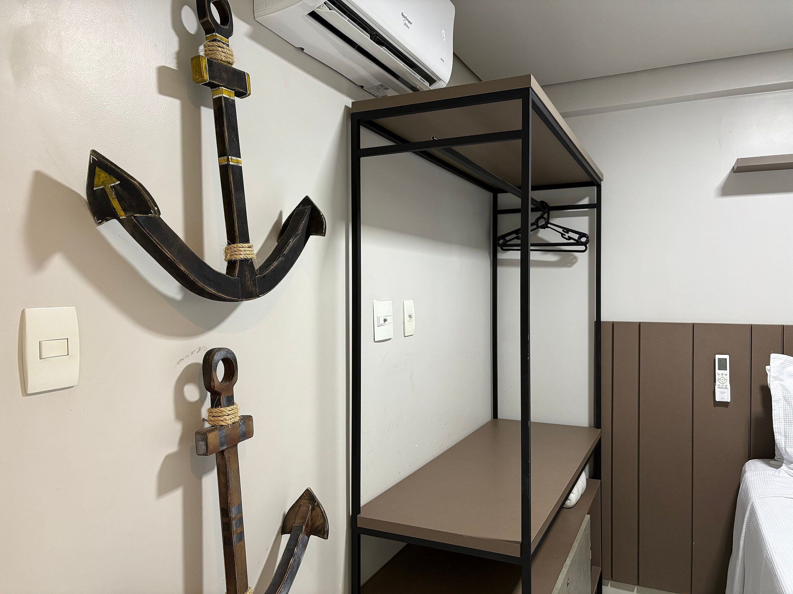 Een stapelbed met een metalen frame, een wandairconditioner en een handdoekhouder.