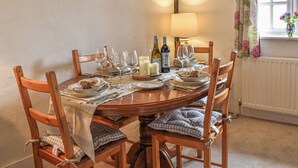 A dining table set for six with chairs, a painting on the wall, a window with curtains, and a lamp. - 2 bedroom accommodation in Hailsham (Hailsham)