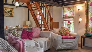 A cozy living room with a sofa set, a wooden staircase, and a green rug. - 2 bedroom accommodation in Hailsham (Hailsham)