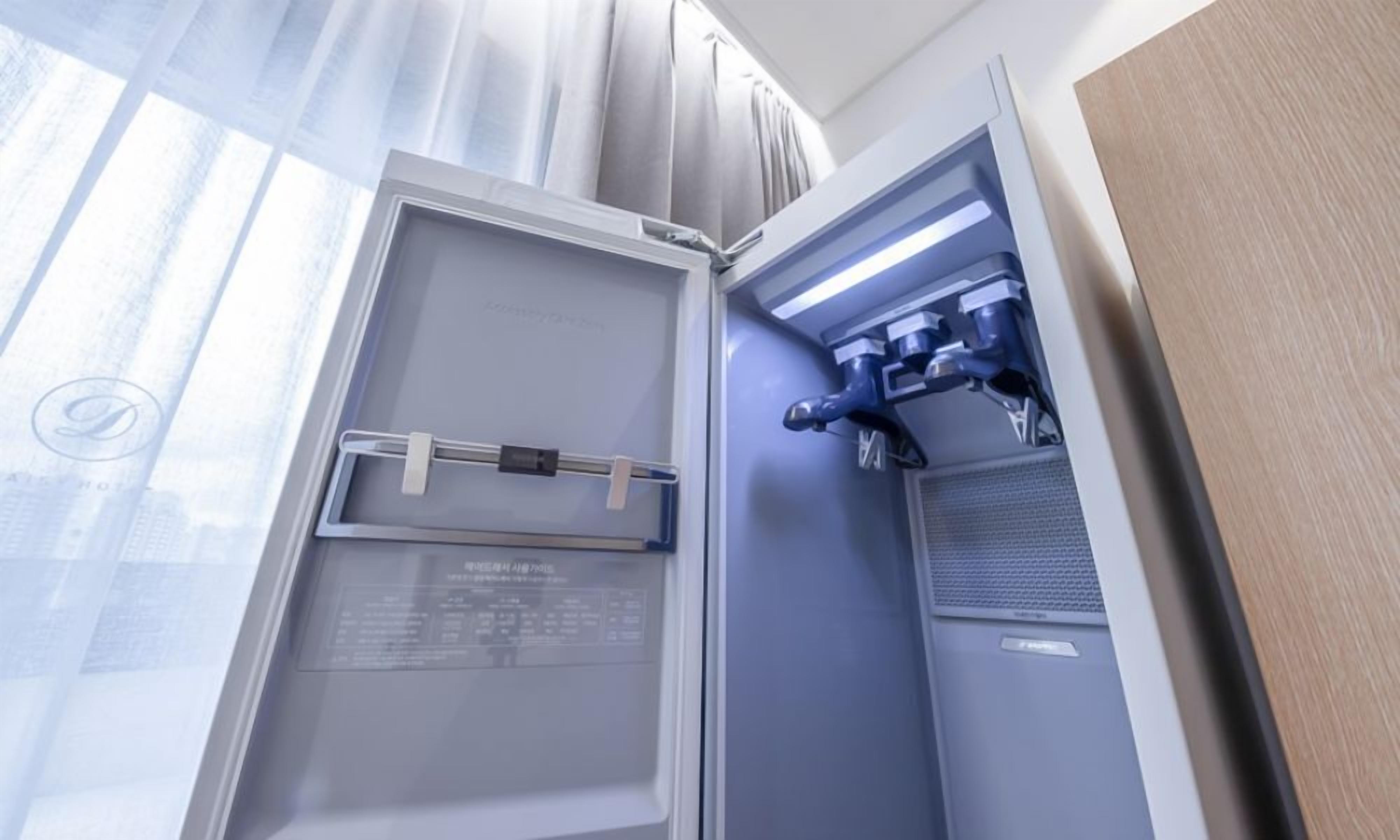 Une chambre d’hôtel moderne dotée d’une grande fenêtre, d’un bureau intégré et d’un panneau de commande.
