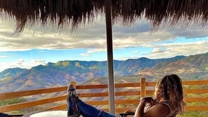 Una persona sentada a una mesa con vistas a montañas.