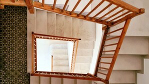 Una escalera de madera con vistas a un muro de azulejos y una ventana.