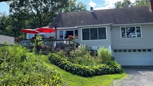 Une maison dotée d’un patio couvert, d’un garage et d’un jardin bien entretenu.