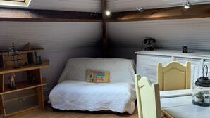 A cozy attic bedroom with a bed, wooden floor, and a dining table with chairs. - Loft 1er Étage (Andernos-les-Bains)