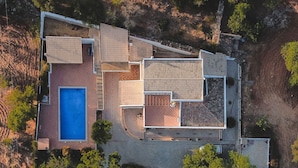Vue aérienne d’une maison moderne dotée d’une piscine, d’un patio et d’une allée.
