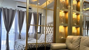 A modern bedroom with a large bed, a sofa, and a decorative chandelier. - Deluxe Suit Room (Pasay)