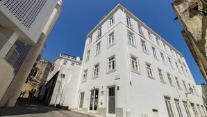 A white building with multiple windows and a door, located in a narrow street with other buildings. - Fully new refurbished Alfama Central Cosy Home (Lisboa)