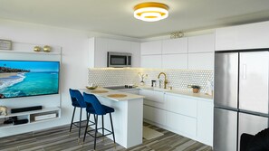 Enjoy cooking in this well-equipped kitchen with a central island, flat-screen TV, and stainless steel appliances.