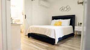 A bedroom with a bed, bedside table, and wall decor.