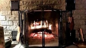 Una chimenea con una pared de ladrillo y un letrero encima que dice 'Deer Crossing'.