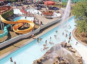 A water park with multiple slides and pools, surrounded by a fenced area with seating and umbrellas. - PET FRIENDLY Adirondacks Log Cabin! Lake George, Saratoga, SPAC, Sacandaga (Stony Creek)