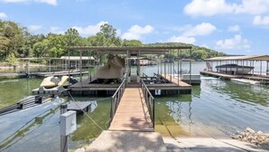 Un quai doté d’un espace de stockage pour bateaux abrité, un ciel dégagé et un lac paisible.