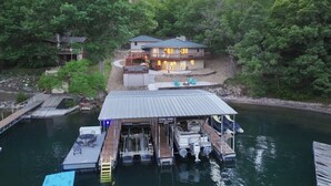 Une propriété au bord du lac, dotée d’un quai, d’une maison avec une zone abritée et d’un bateau.